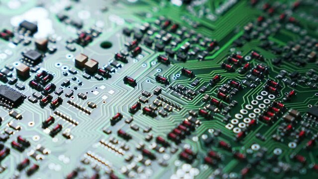 Extreme closeup shot of various electric components and chips placed onto vivid green PCB board. Modern technology basis. High quality 4k footage