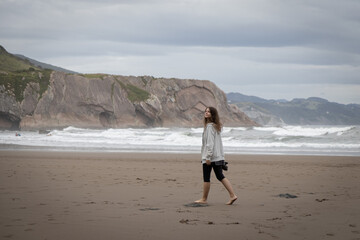 Girl walks on the Itzurun Beach in Zumaia, Basque Country, Spain.