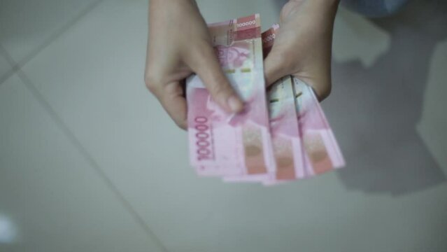 woman hand showing rupiah Indonesian money