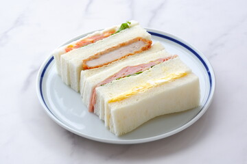トンカツやタマゴ、ハム、生野菜のサンドイッチ