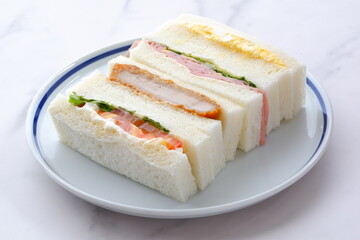 トンカツやタマゴ、ハム、生野菜のサンドイッチ
