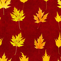 Seamless pattern of real multi-colored autumn leaves on a red velvet background