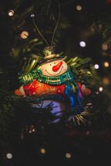 Snowman ornament on the Christmas tree with lights