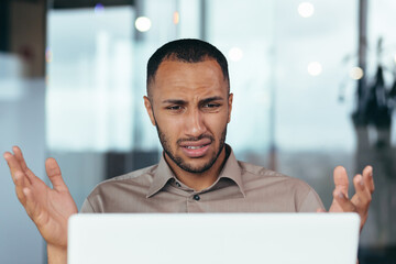Upset businessman close up looking at laptop screen at work, man unhappy with received email...