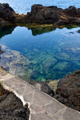 Naturalne baseny z lawy i wody morskiej, zabezpieczone, w których można pływać z falami