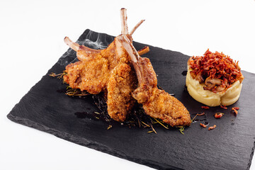 Roasted pork ribs, garnished with onion chips and mashed potatoes