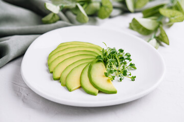 Sliced avocado on white plate