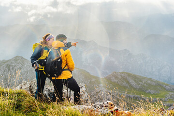 Obraz premium couple of hikers with their dog making a mountain route in the rain. sports and outdoor weekend activities