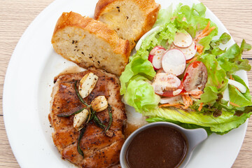 Pork sirloin steak with gravy sauce, salad and garlic bread
