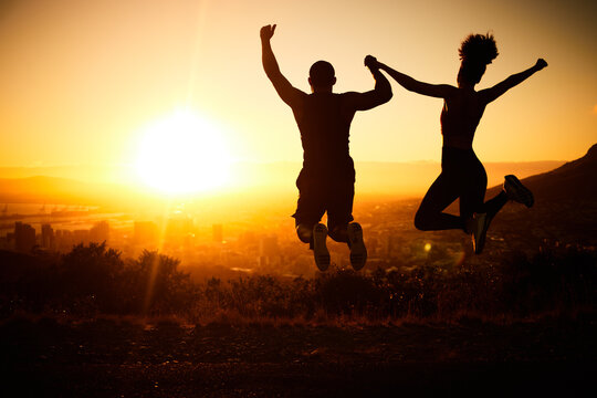 Sunset silhouette, couple jumping and a nature hike adventure for winning fitness exercise, fun holiday and city view. Summer cardio, outdoor training and workout motivation for body health success