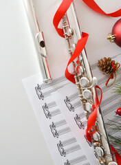 Metal flute detail music and Christmas decoration on white table © Davizro Photography