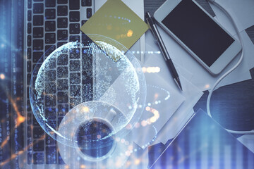 Double exposure of map hologram drawing over study table background with computer. Concept of international network. Top view.