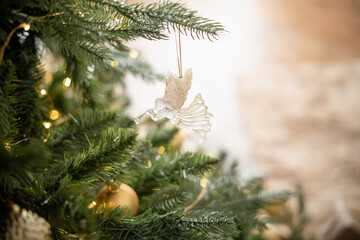 Fototapeta na wymiar Glass toy angel on a Christmas tree branch. 