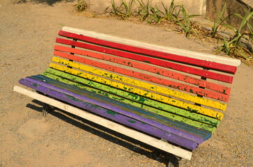 Antigua banca de parque de muchos colores con concepto LGBT en un parque de la ciudad de Salta,...