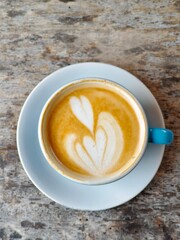 Hot coffee latte in a blue cup on wood table background