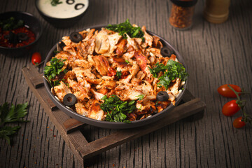 Delicious chicken shawarma with tahini sauce, on a gray and brown background