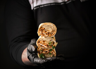Delicious chicken shawarma with tahini sauce, on a gray and brown background