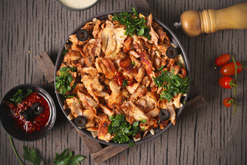 Delicious chicken shawarma with tahini sauce, on a gray and brown background