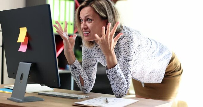 Beautiful woman looks at laptop and expresses shock