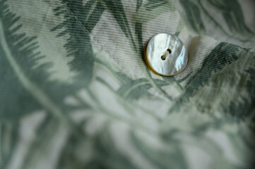 Mother-of-pearl buttons close-up. fashion clothes with buttons. Tropical print fabric