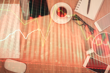 Double exposure of financial chart hologram over desktop with phone. Top view. Mobile trade platform concept.