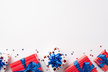USA Independence Day celebration concept. Top view photo of gift boxes with ribbon bows and star shaped confetti on isolated white background with copyspace