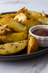 Naklejka na ściany i meble Oven roasted potatoes with skins, sliced, with sauces close-up