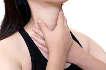 A woman suffering from esophagitis is touching her wrinkled neck.