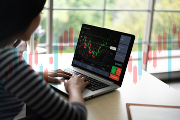 Young business woman using computer trading stock market exchange online. Trader analyzing data and...