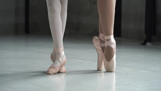 Young ballerinas are balancing while standing on their toes, training session.