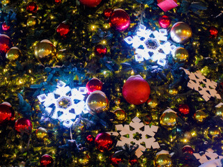 Close up of red christmas balls, snow flakes and golden garland night street lights on Chrismas...