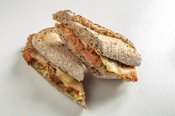 Sándwich de pan integral con atún tomate y queso. Whole wheat bread sandwich with tomato tuna and cheese.