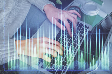 Double exposure of woman hands typing on computer and forex chart hologram drawing. Stock market invest concept.