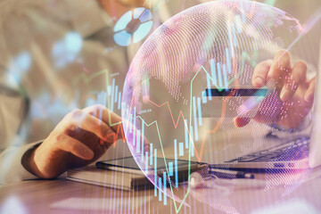 Double exposure of man hands holding a credit card and Forex graph drawing. Stock trading and...