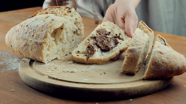 Chocolate Spread On Sourdough Bread. Knife Spreading Chocolate Spread On Sandwich Breakfast On Rye Bread. Knife Smearing Chocolate Butter Spread On Freshly Baked Bread Slice. Culinary At Breakfast