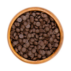 Bittersweet chocolate drops, couverture in a wooden bowl.  Chocolate coating mass in drop form,...