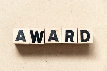 Alphabet letter block in word award on wood background