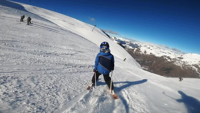 Small kid learning how ski in the mountains