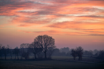 Obraz premium Stunning sunset in the countryside with colorful clouds during a cold winter day