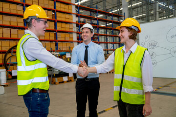 Professional manager clap hands for the team with warehouse worker man shake hands with co-worker woman and they smiling with happiness.