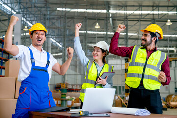 Group of Asian warehouse worker raise hands and action of happy from success in their project and stay in workplace with several tools on table.
