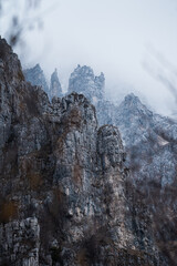 Fototapeta na wymiar Sharp rock formations in the mountains near Lake Como surrounded by the fog