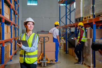 Asian warehouse worker woman hold tablet and look up to the shelves to support workflow in workplace area.