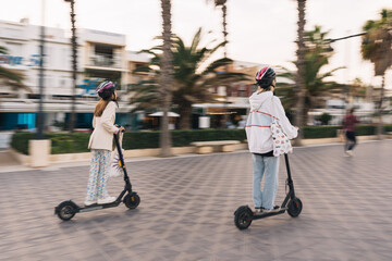 Two young girls riding electric scooter © AntonioJavier