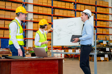 Warehouse worker woman write on white board to explain about project workflow and plan to her...