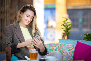 young lady using smart phone while at cafe