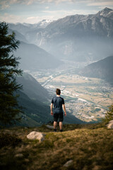 Fototapeta premium A person is looking over the Chiavenna Valley from the top of Mount Berlinghera, in the Northern Italy