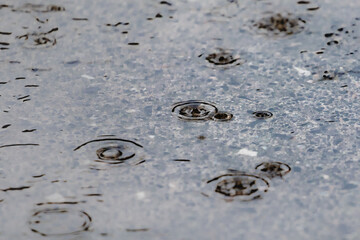 Rainy day on the street. Rainwater falling on the asphalt ground. Rain in autumn.