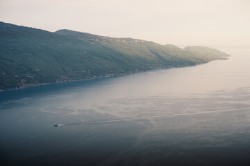 Aerial view of the east coast of Lake Garda, with some sunlight shining on the hills