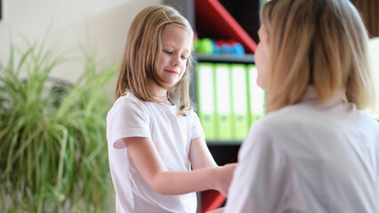 Mother and pretty little daughter play together and talk to each other.